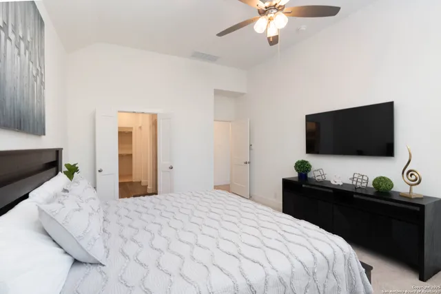 a bedroom with bed tv and window