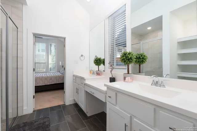 a en suite bathroom with a double vanity sink and mirror