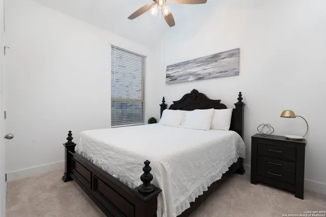 a bedroom with a bed and a ceiling fan