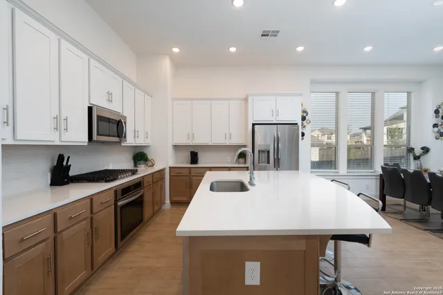 a kitchen with kitchen island a sink appliances and cabinets