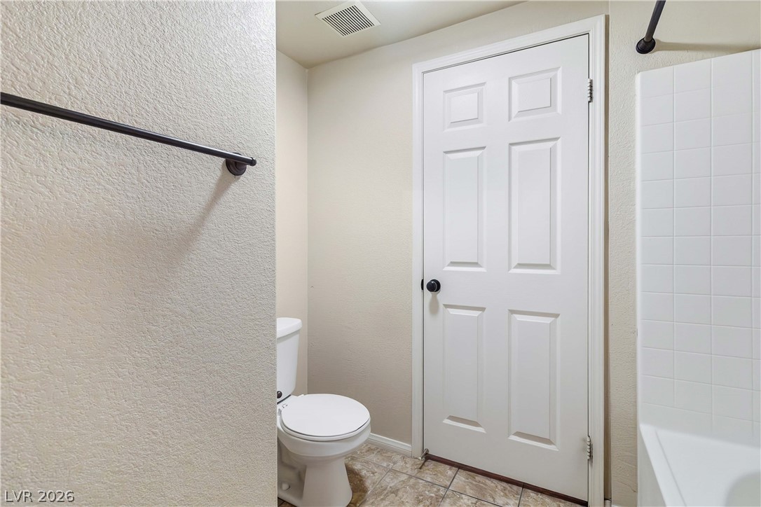10550 West Alexander Road, Unit 2060 Las Vegas, NV 89129 - Photo 31 of 45 Functional bathroom with tiled flooring, a clean toilet, and a convenient towel rack.