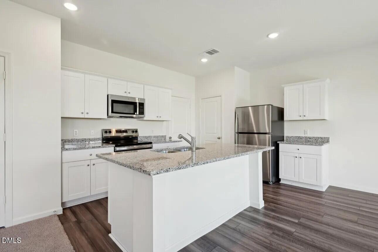 1325 Solace Way Rolesville, NC 27571 - Photo 11 of 29 a kitchen with stainless steel appliances a refrigerator stove microwave and sink