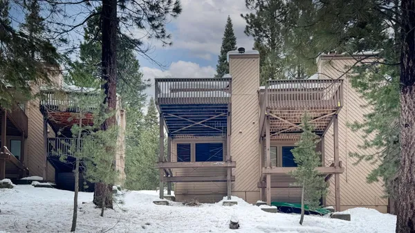 a front view of a house with a tree