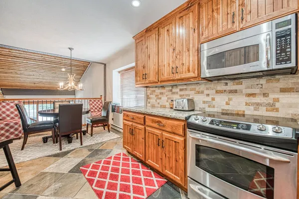 a kitchen with stainless steel appliances granite countertop a stove a sink and a microwave