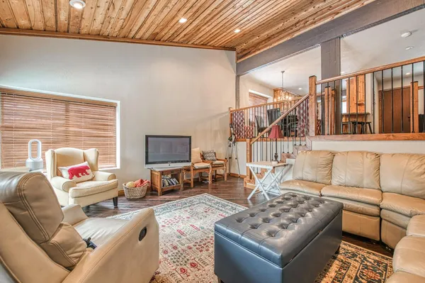 a living room with furniture and a flat screen tv with wooden floor