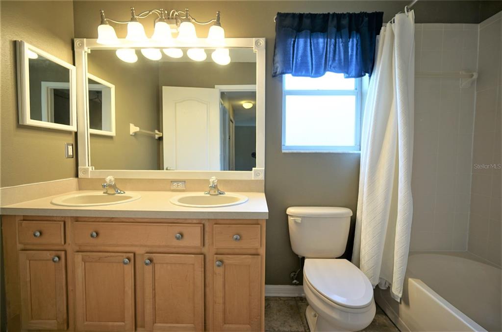 13603 Sigler Street Riverview, FL 33579 - Photo 26 of 37 a bathroom with a toilet a sink a tub and mirror