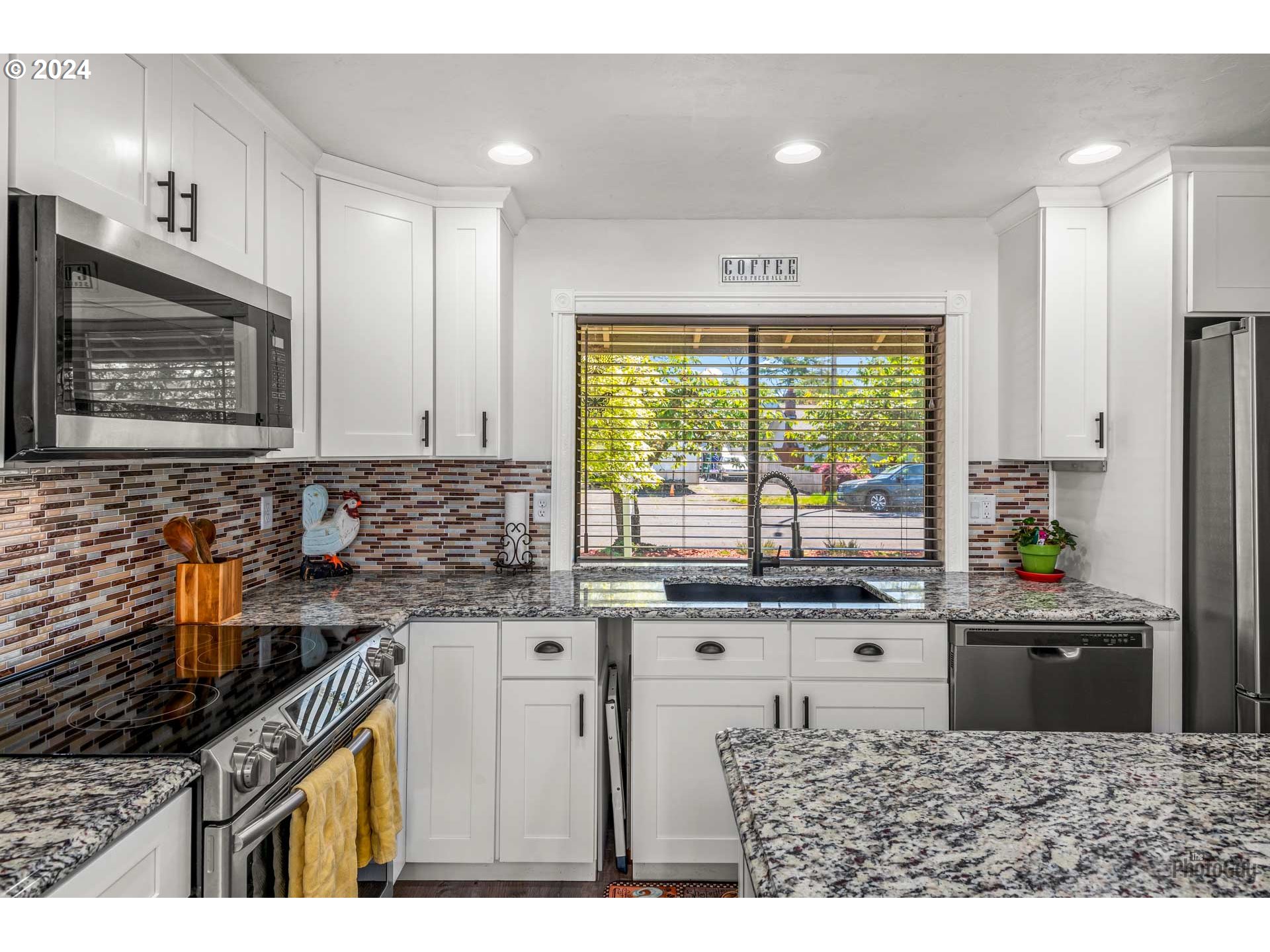666 56th Street Springfield, OR 97478 - Photo 13 of 31 a kitchen with granite countertop a stove a sink and a microwave