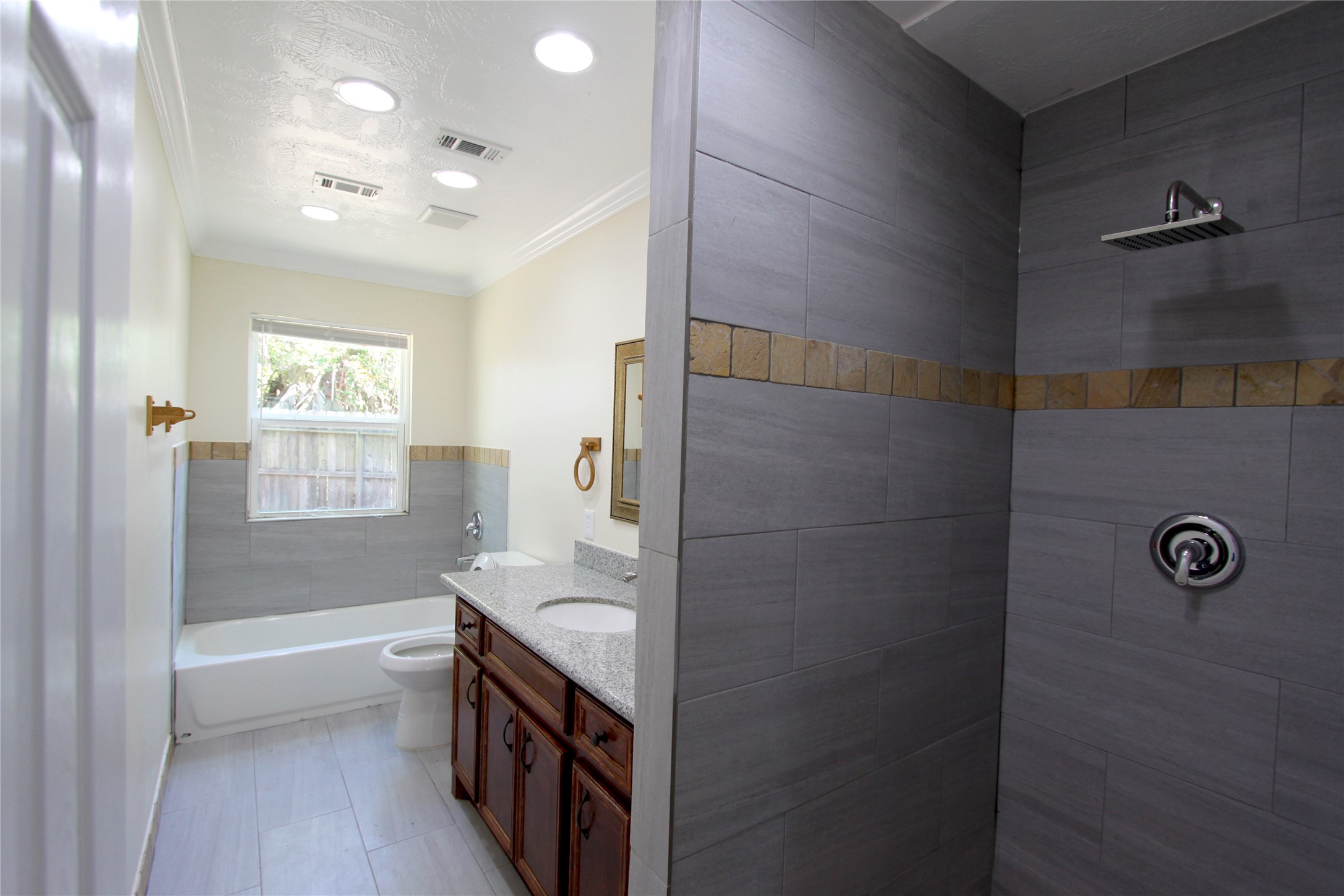4330 Regency Villa Drive Houston, TX 77084 - Photo 11 of 13 a bathroom with a granite countertop sink a mirror and a bathtub
