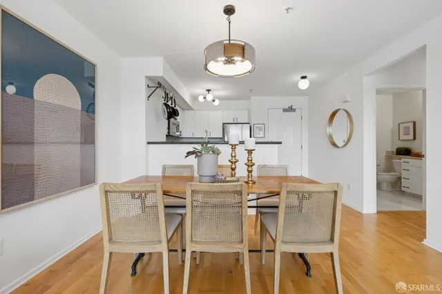 a dining room with wooden floor a glass table and chairs