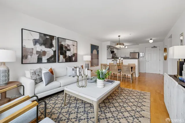 a living room with furniture and a view of kitchen
