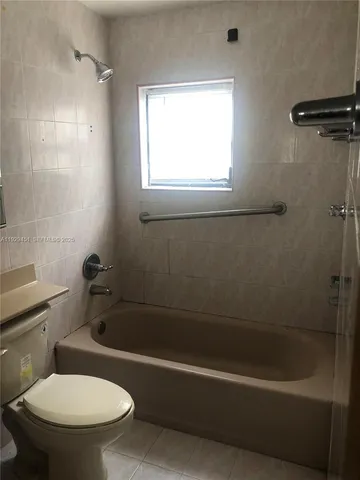 a white bath tub sitting next to a toilet