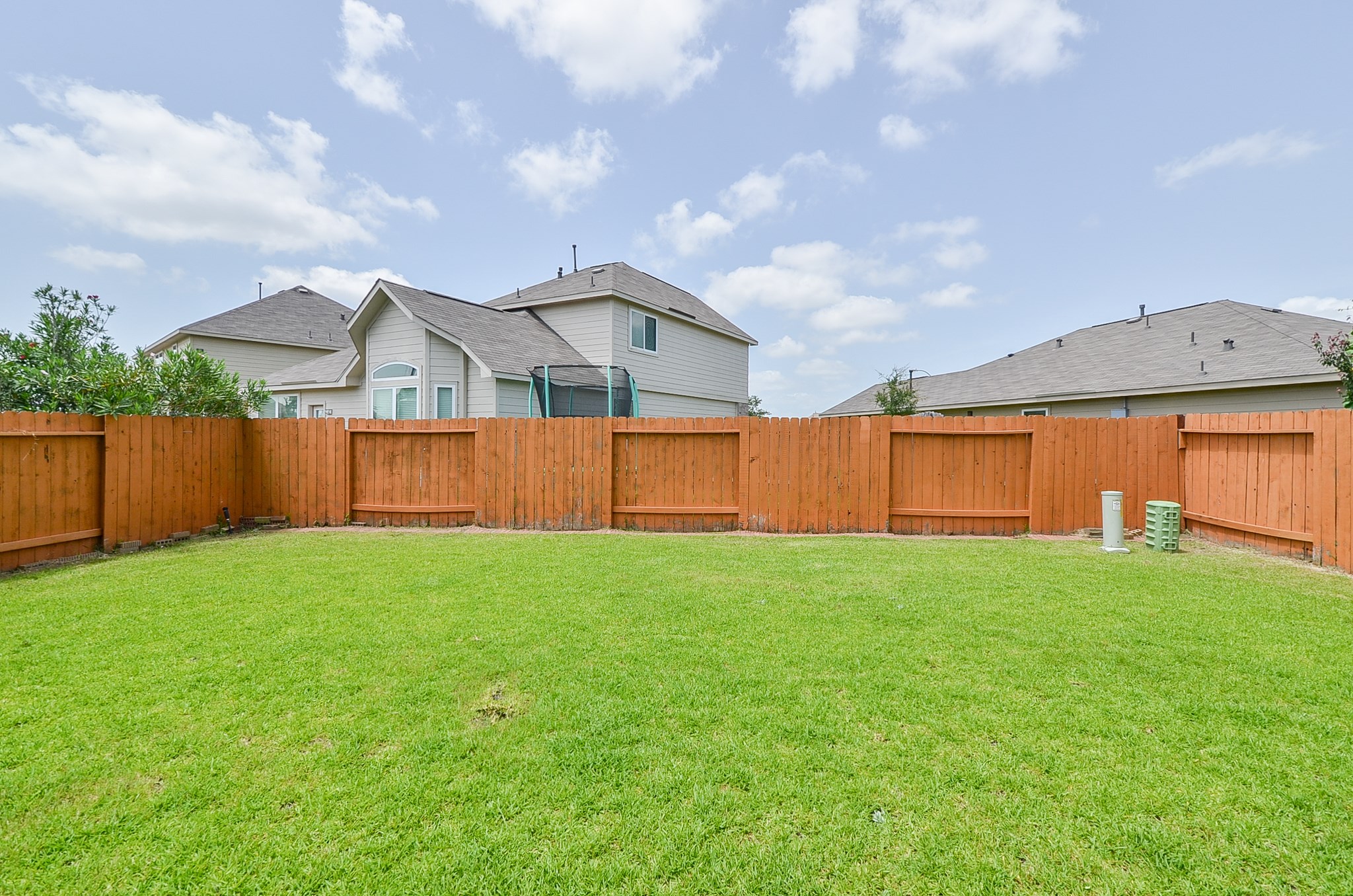 25135 Ginger Ranch Drive Katy, TX 77494 - Photo 32 of 32 Wide open green space provides a clean canvas for outdoor living, framed by a privacy fence.