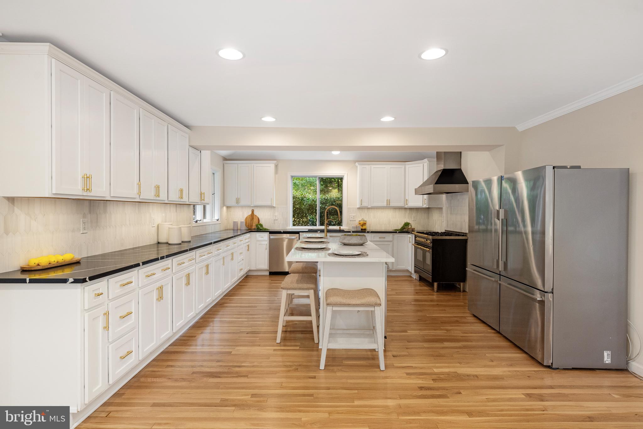 4 Bucksway Road Owings Mills, MD 21117 - Photo 10 of 57 a kitchen with granite countertop a refrigerator oven a sink a dining table and chairs with wooden floor