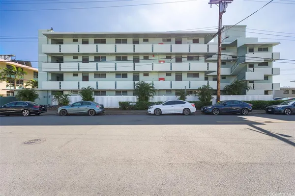 a front view of a building with cars