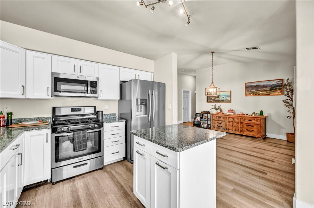1234 Sunfire Street Henderson, NV 89014 - Photo 8 of 40 A well-appointed kitchen features stainless steel appliances, granite countertops, and an inviting island, perfect for entertaining.