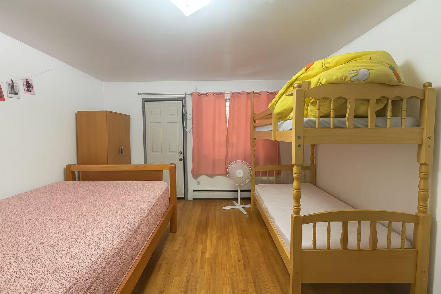 108-11 44th Avenue Queens, NY 11368 - Photo 6 of 11 a bedroom with a bed and wooden floor