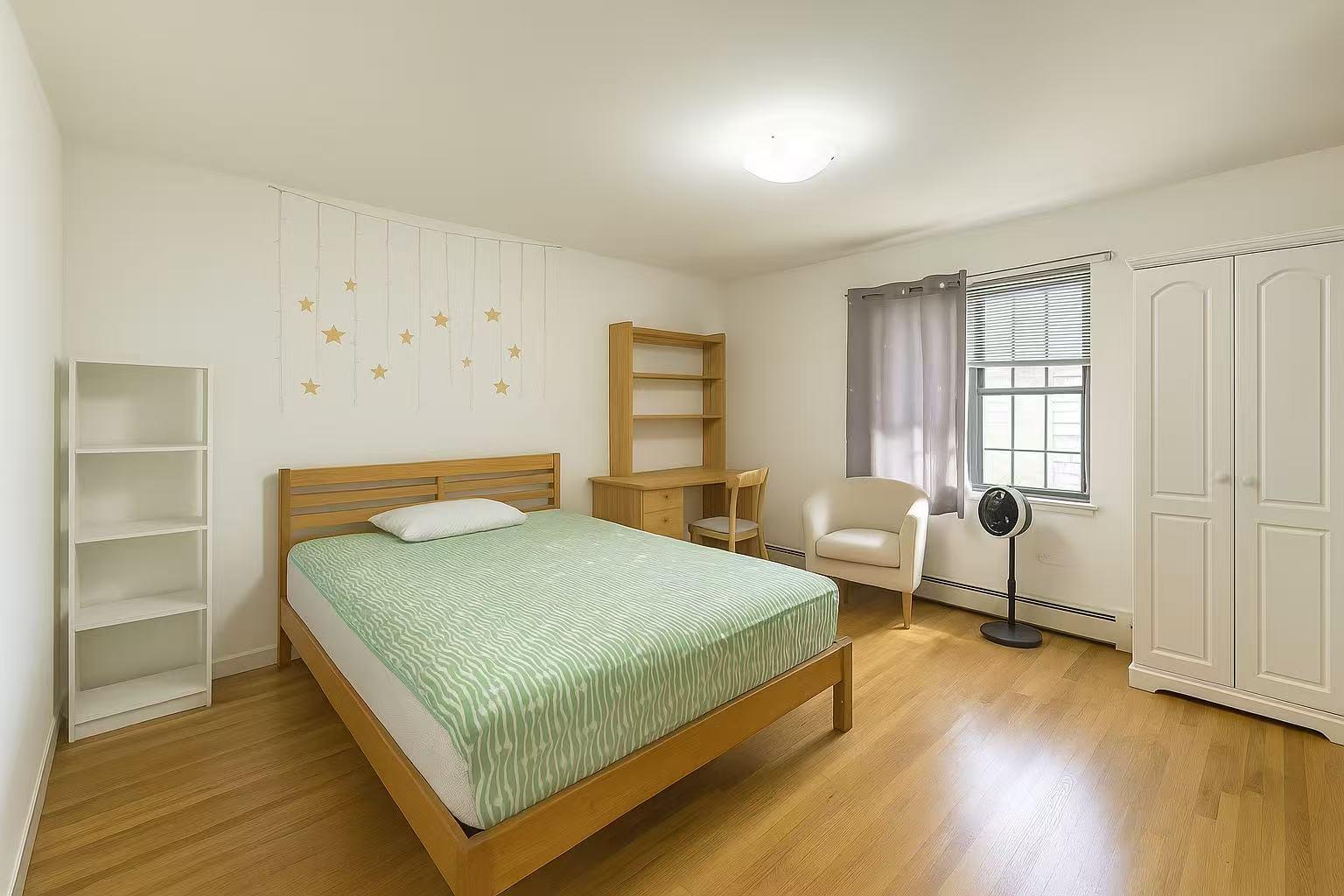 108-11 44th Avenue Queens, NY 11368 - Photo 8 of 11 a bedroom with a bed and windows