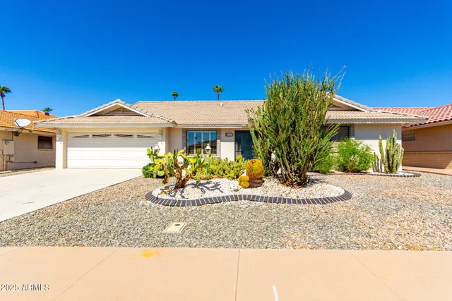a front view of a house with a garden