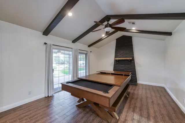 a room with wooden floor and pool table