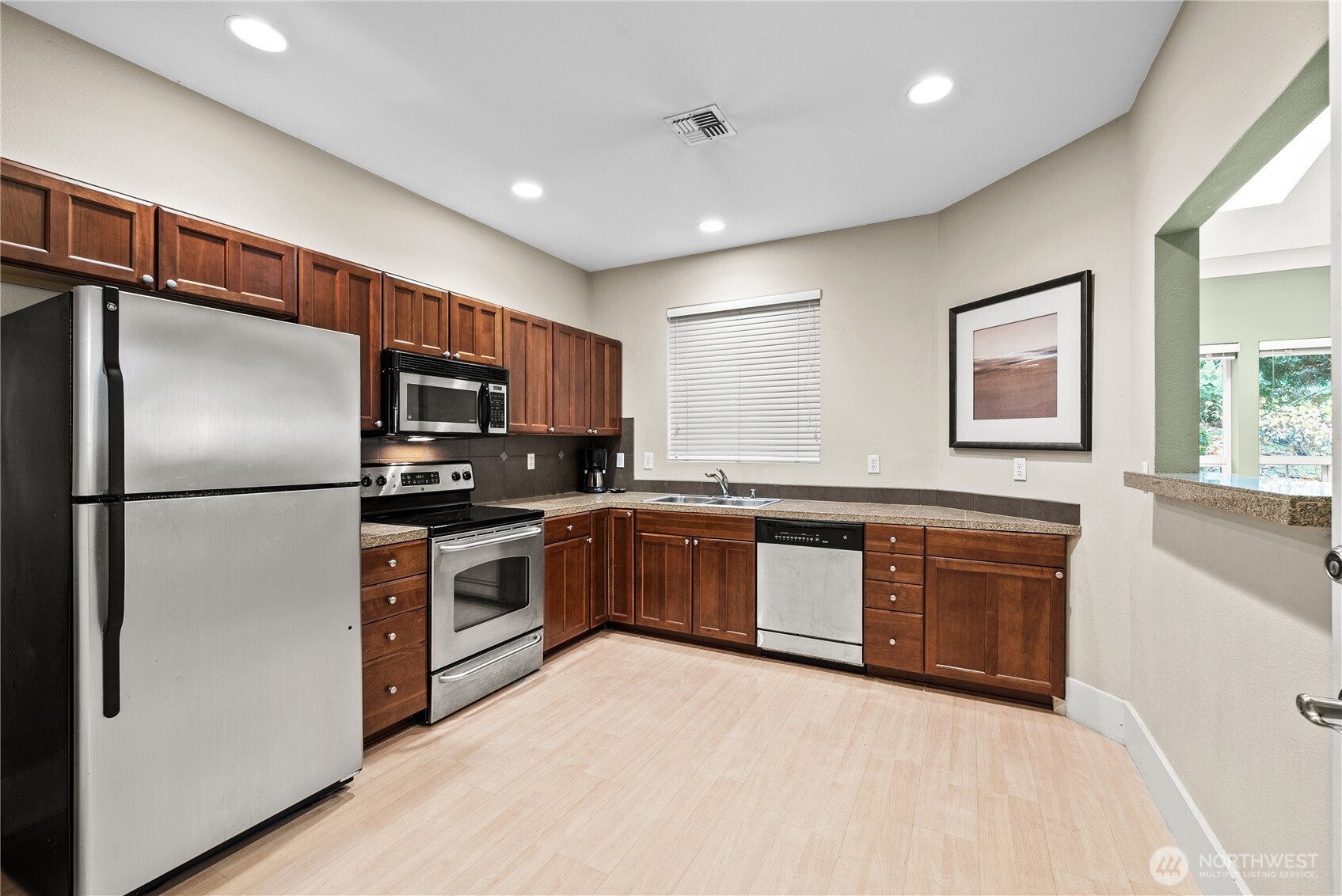 18930 Bothell Everett Highway, Unit G103 Bothell, WA 98012 - Photo 17 of 25 a kitchen with stainless steel appliances granite countertop a refrigerator a stove a sink and a microwave