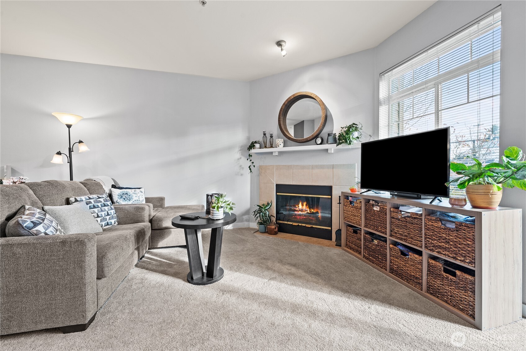 18930 Bothell Everett Highway, Unit G103 Bothell, WA 98012 - Photo 6 of 25 a living room with furniture a flat screen tv and a fireplace
