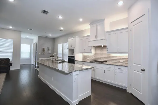 a bathroom with a granite countertop sink a mirror and shower