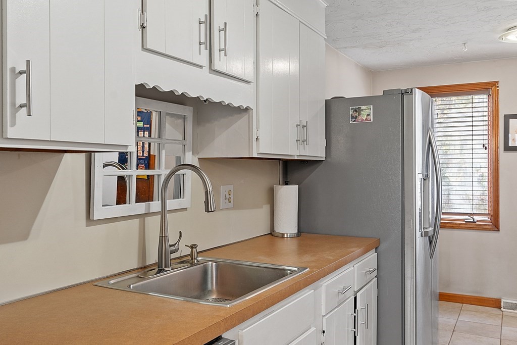 403 Cardinal Lane, Unit 403 Tyngsborough, MA 01879 - Photo 12 of 27 a kitchen with stainless steel appliances granite countertop a sink and a microwave