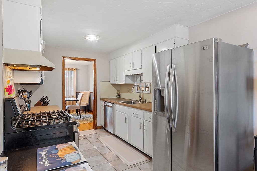 403 Cardinal Lane, Unit 403 Tyngsborough, MA 01879 - Photo 13 of 27 a kitchen with stainless steel appliances granite countertop a refrigerator and a stove top oven