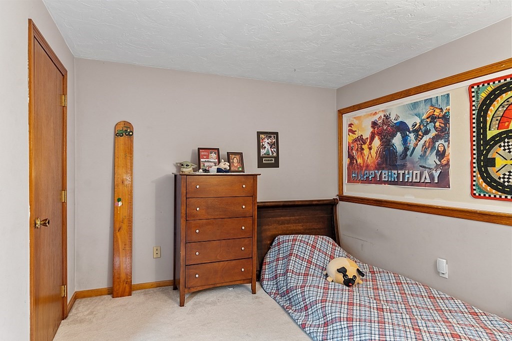 403 Cardinal Lane, Unit 403 Tyngsborough, MA 01879 - Photo 15 of 27 a bedroom with a bed and wooden floor