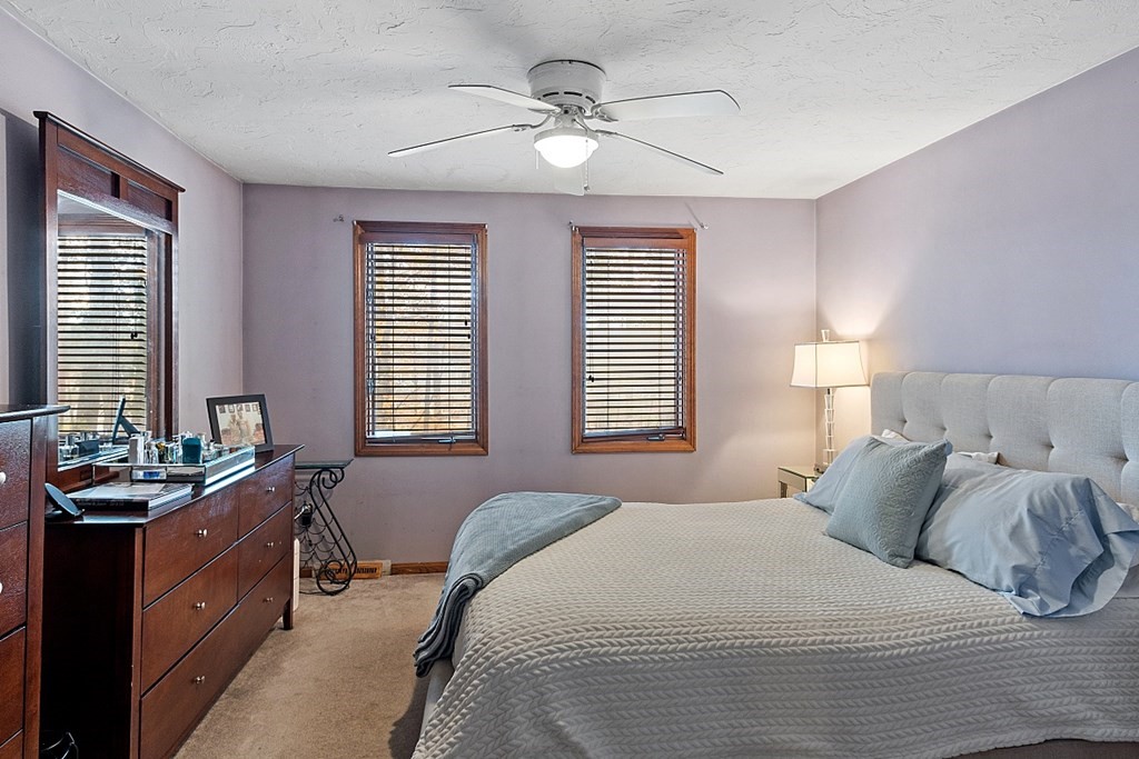 403 Cardinal Lane, Unit 403 Tyngsborough, MA 01879 - Photo 17 of 27 a bedroom with a bed and windows