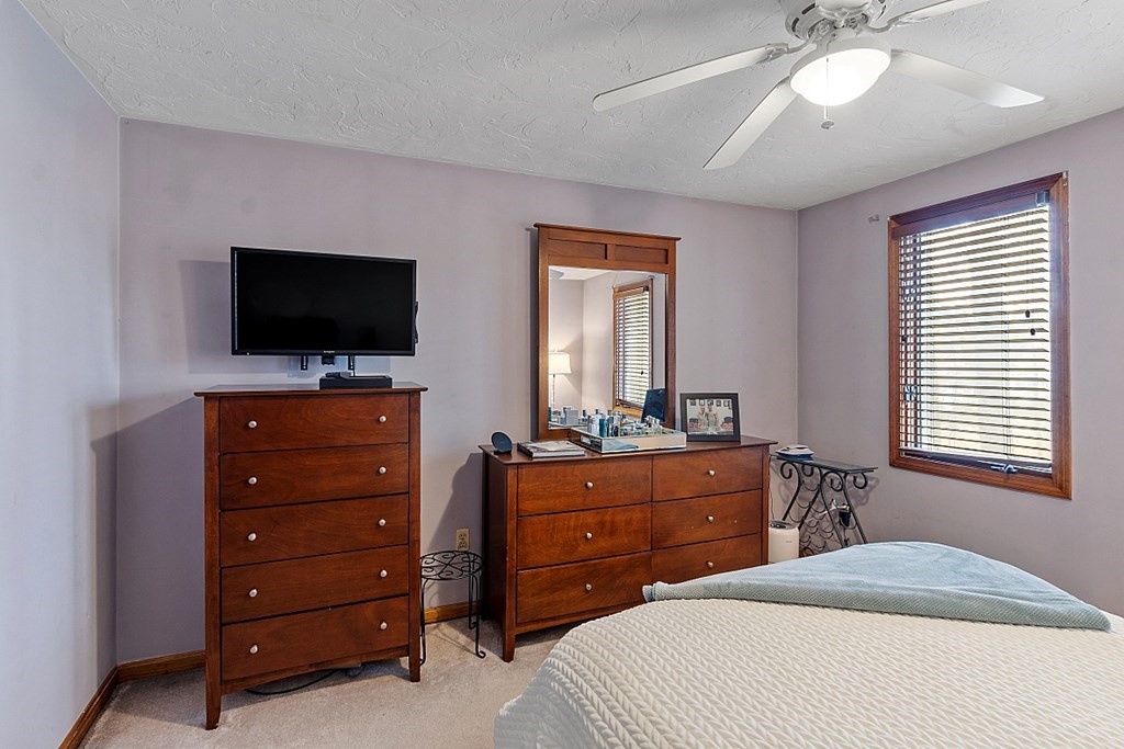 403 Cardinal Lane, Unit 403 Tyngsborough, MA 01879 - Photo 18 of 27 a bedroom with a bed and a flat screen tv