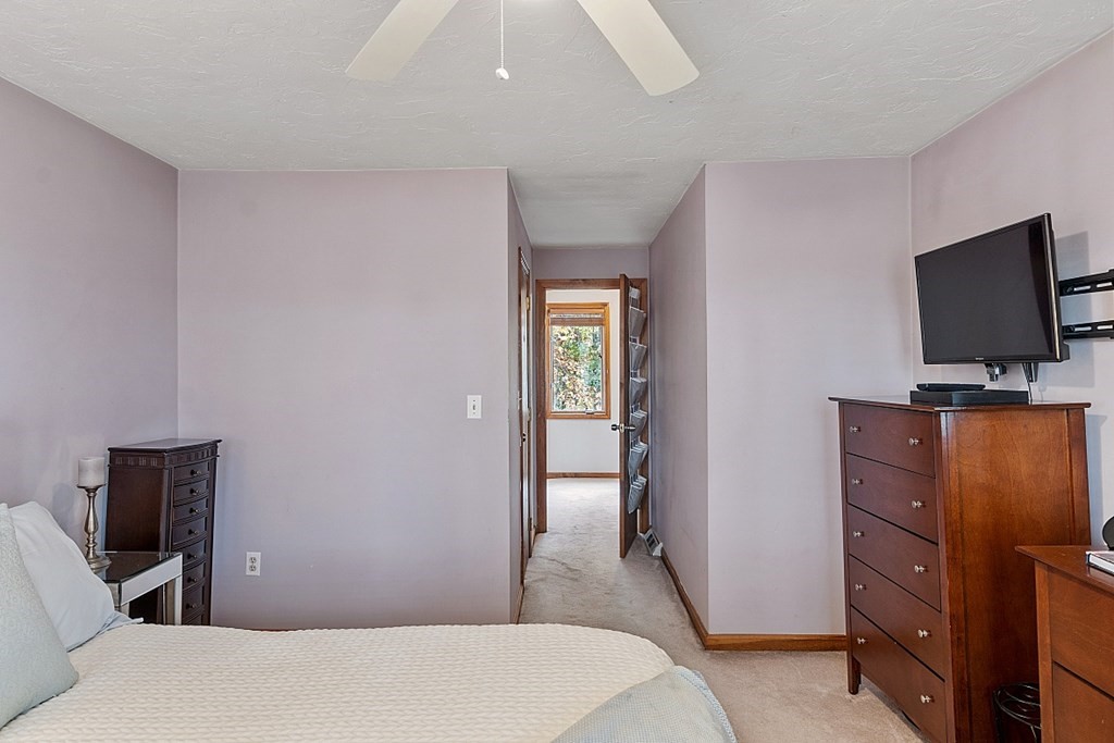 403 Cardinal Lane, Unit 403 Tyngsborough, MA 01879 - Photo 19 of 27 a bedroom with a bed and wooden floor