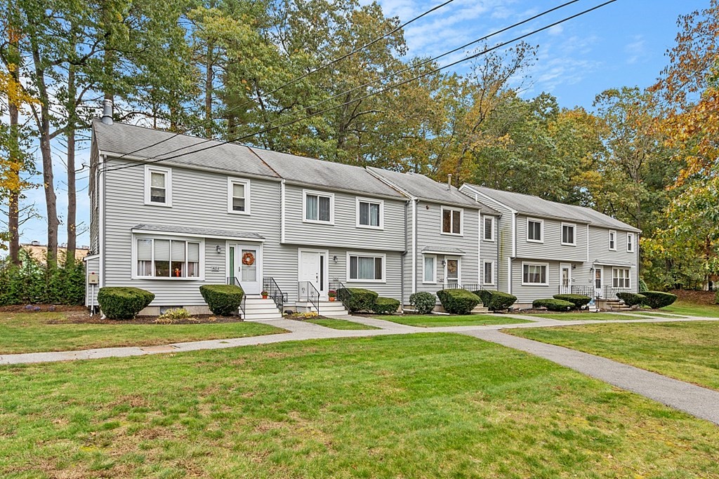 403 Cardinal Lane, Unit 403 Tyngsborough, MA 01879 - Photo 22 of 27 a front view of a building with garden and trees
