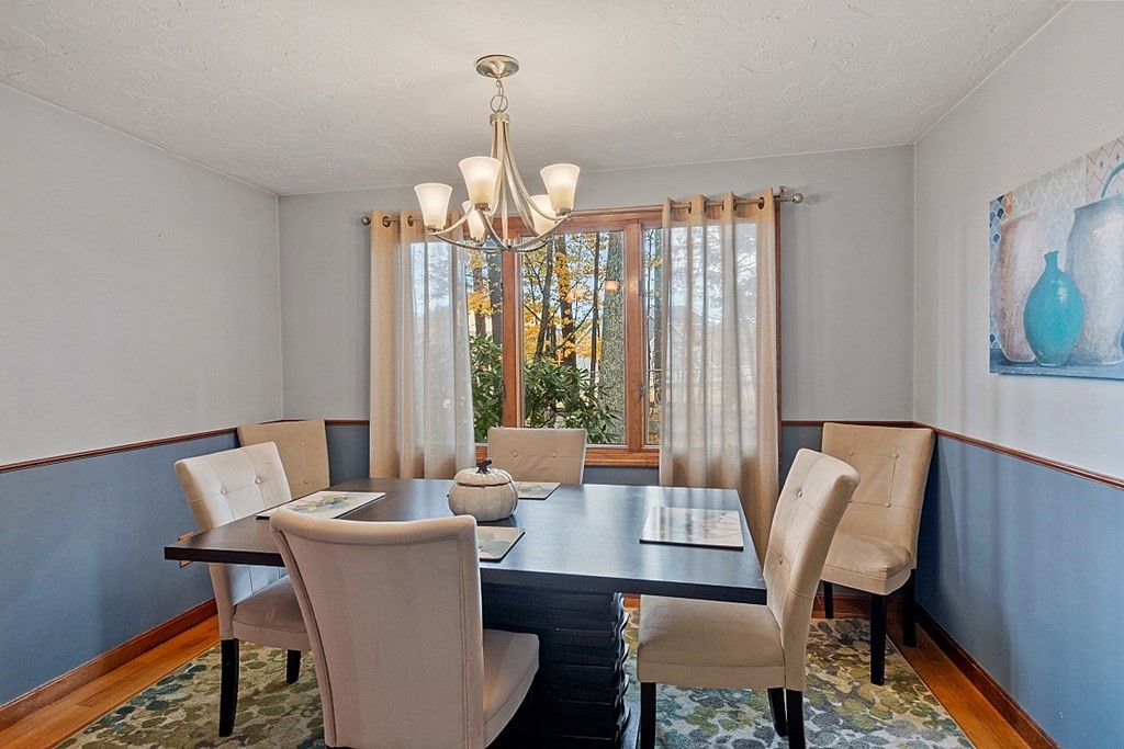403 Cardinal Lane, Unit 403 Tyngsborough, MA 01879 - Photo 9 of 27 a view of a dining room with furniture a rug and wooden floor