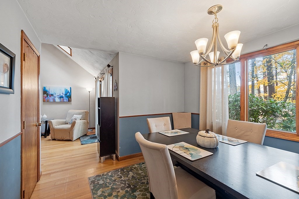 403 Cardinal Lane, Unit 403 Tyngsborough, MA 01879 - Photo 10 of 27 a view of a dining room with furniture wooden floor and chandelier