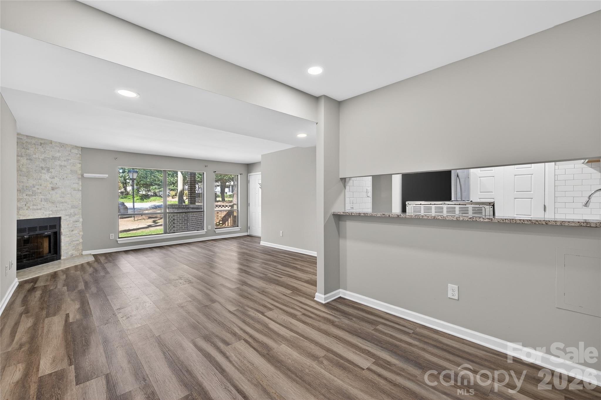 1612 Sharon Road West, Unit 67 Charlotte, NC 28210 - Photo 11 of 19 a view of an empty room with wooden floor and a window