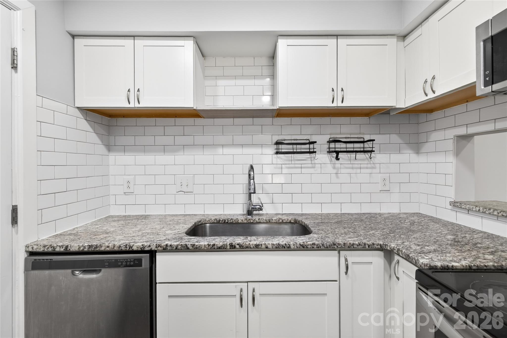 1612 Sharon Road West, Unit 67 Charlotte, NC 28210 - Photo 12 of 19 a kitchen with granite countertop cabinets stainless steel appliances and a sink