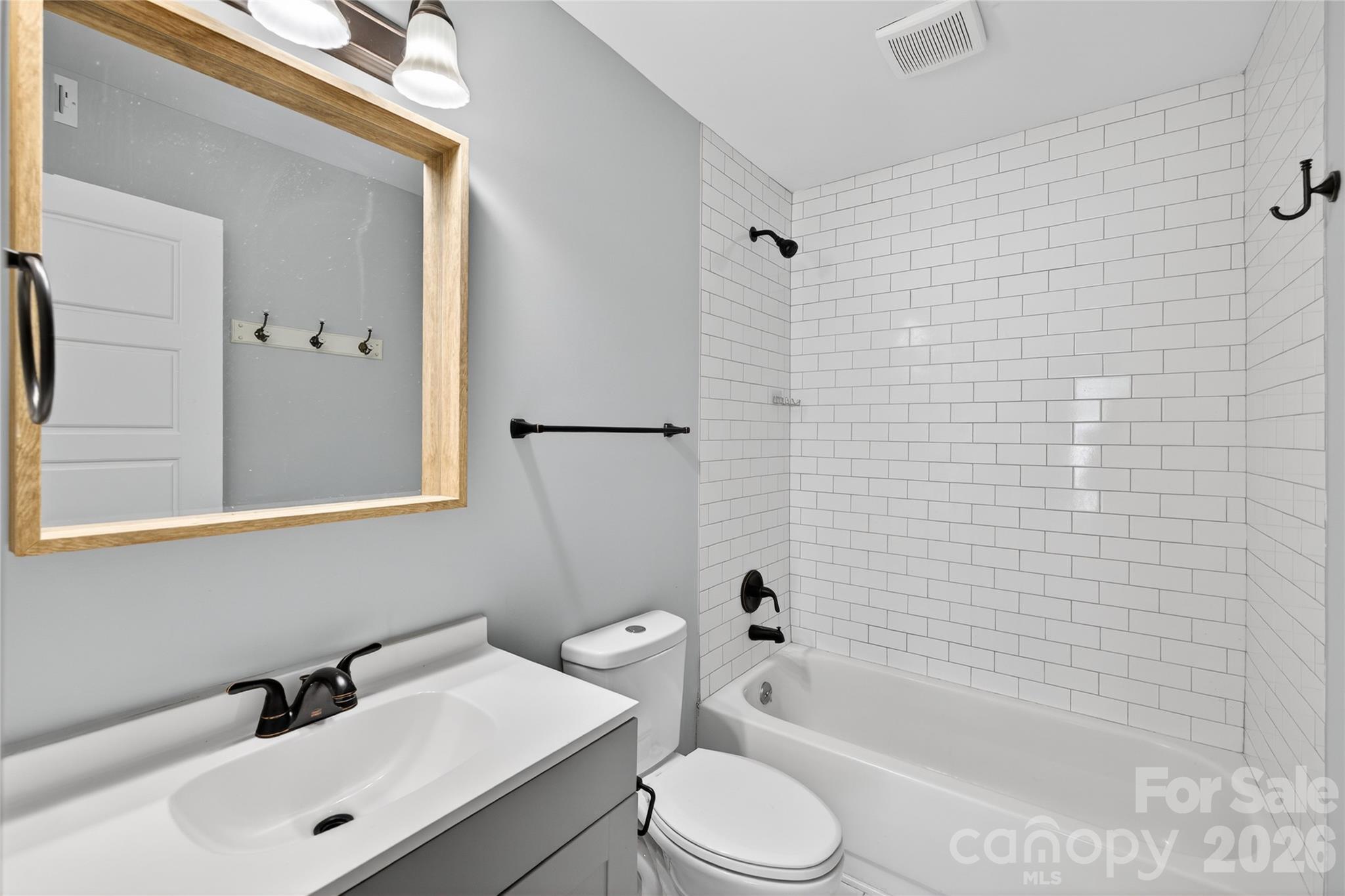 1612 Sharon Road West, Unit 67 Charlotte, NC 28210 - Photo 17 of 19 a bathroom with a bathtub shower sink vanity and toilet