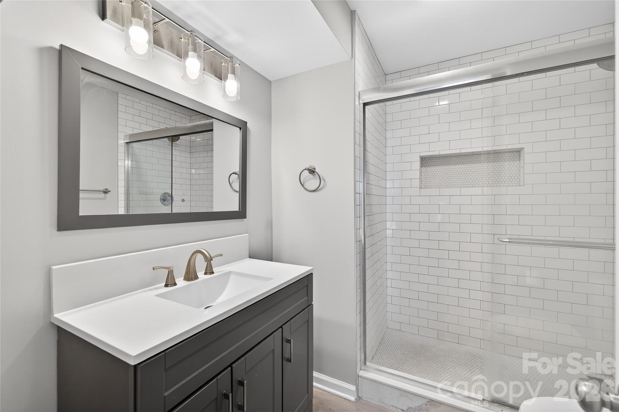 1612 Sharon Road West, Unit 67 Charlotte, NC 28210 - Photo 19 of 19 a bathroom with a sink a mirror and a shower