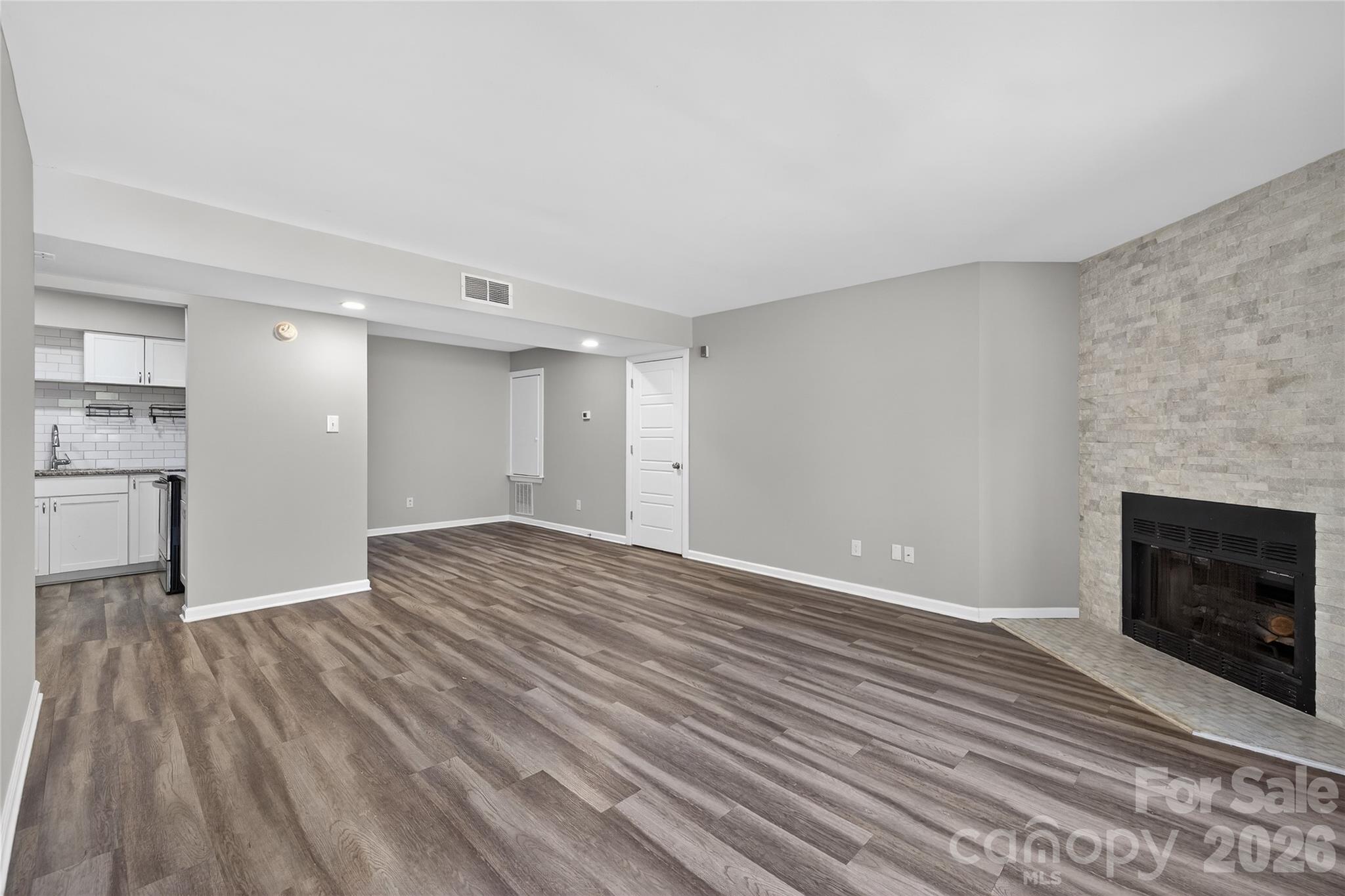 1612 Sharon Road West, Unit 67 Charlotte, NC 28210 - Photo 4 of 19 a view of empty room with wooden floor and fireplace