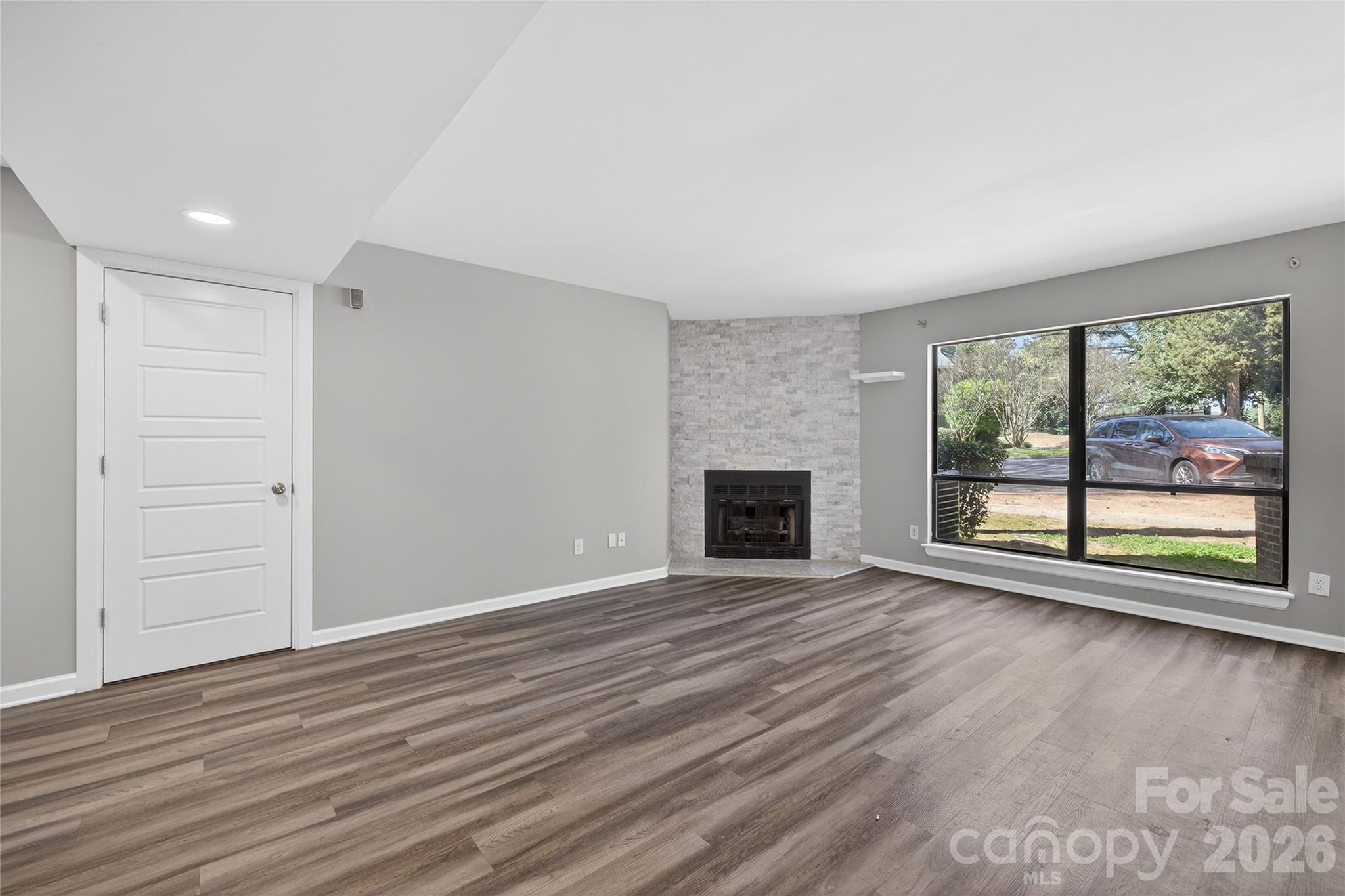 1612 Sharon Road West, Unit 67 Charlotte, NC 28210 - Photo 7 of 19 wooden floor in an empty room with a fireplace