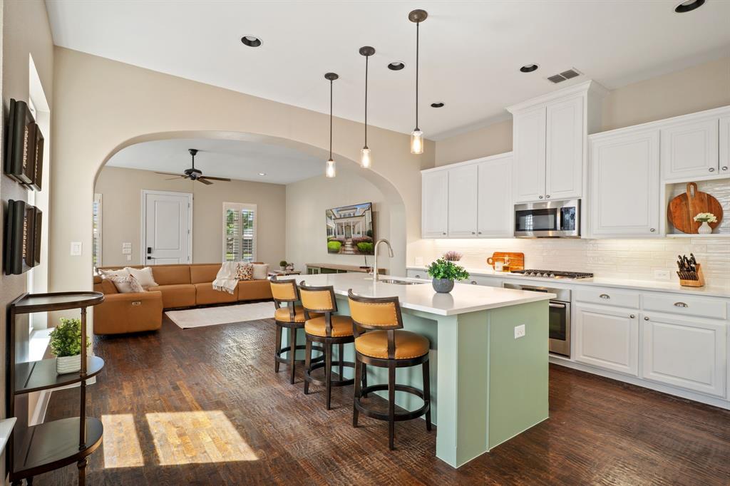 738 East Main Street Coppell, TX 75019 - Photo 9 of 27 a kitchen with stainless steel appliances granite countertop wooden floors and white cabinets