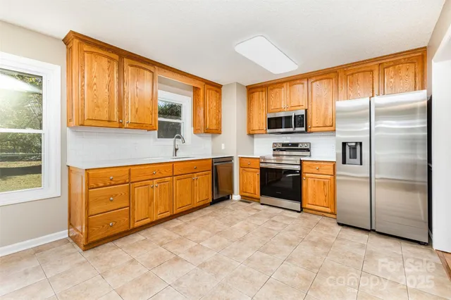 a kitchen with granite countertop stainless steel appliances a stove sink and microwave