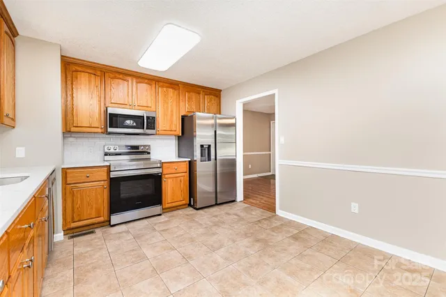 a kitchen with stainless steel appliances a refrigerator and a stove top oven