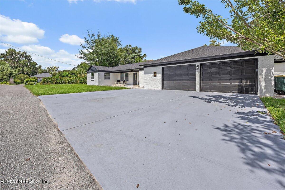 1435 Flanders Road Jacksonville, FL 32207 - Photo 2 of 21 a front view of a house with a yard and garage