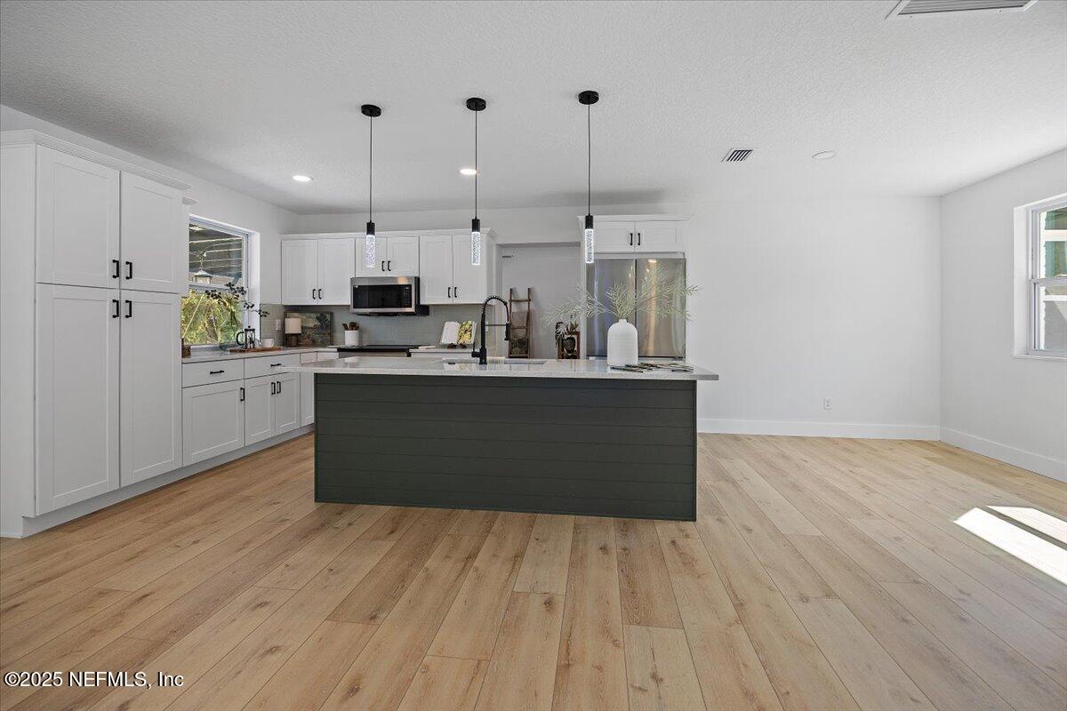 1435 Flanders Road Jacksonville, FL 32207 - Photo 5 of 21 a kitchen with stainless steel appliances granite countertop a sink a stove top oven a counter space and cabinets