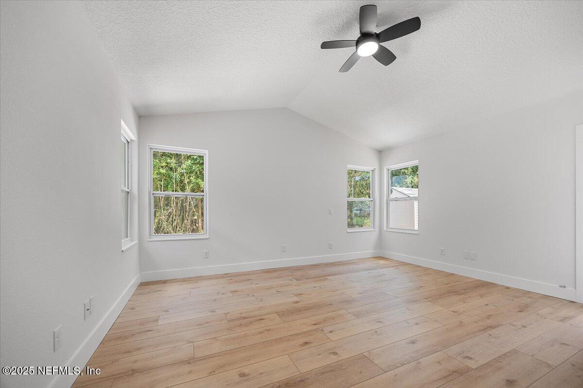 1435 Flanders Road Jacksonville, FL 32207 - Photo 8 of 21 an empty room with wooden floor ceiling fan and windows