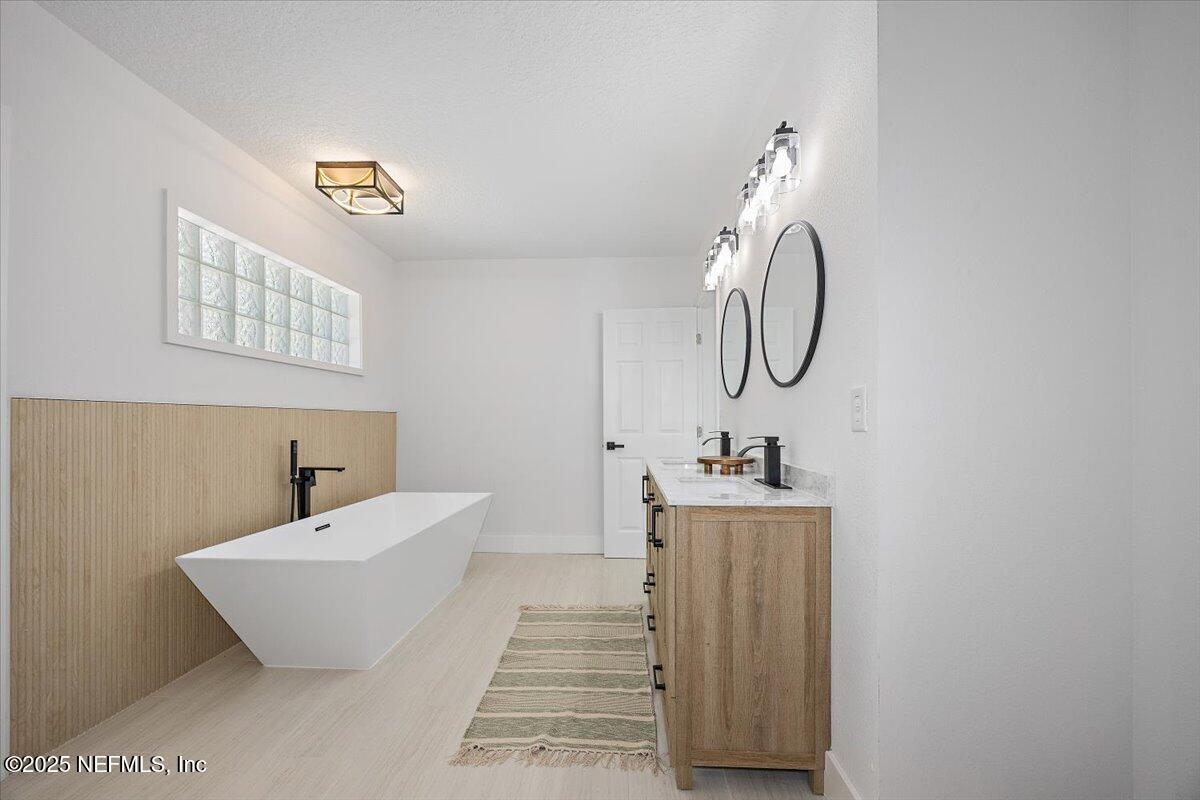 1435 Flanders Road Jacksonville, FL 32207 - Photo 10 of 21 a bathroom with a sink a mirror and a bathtub