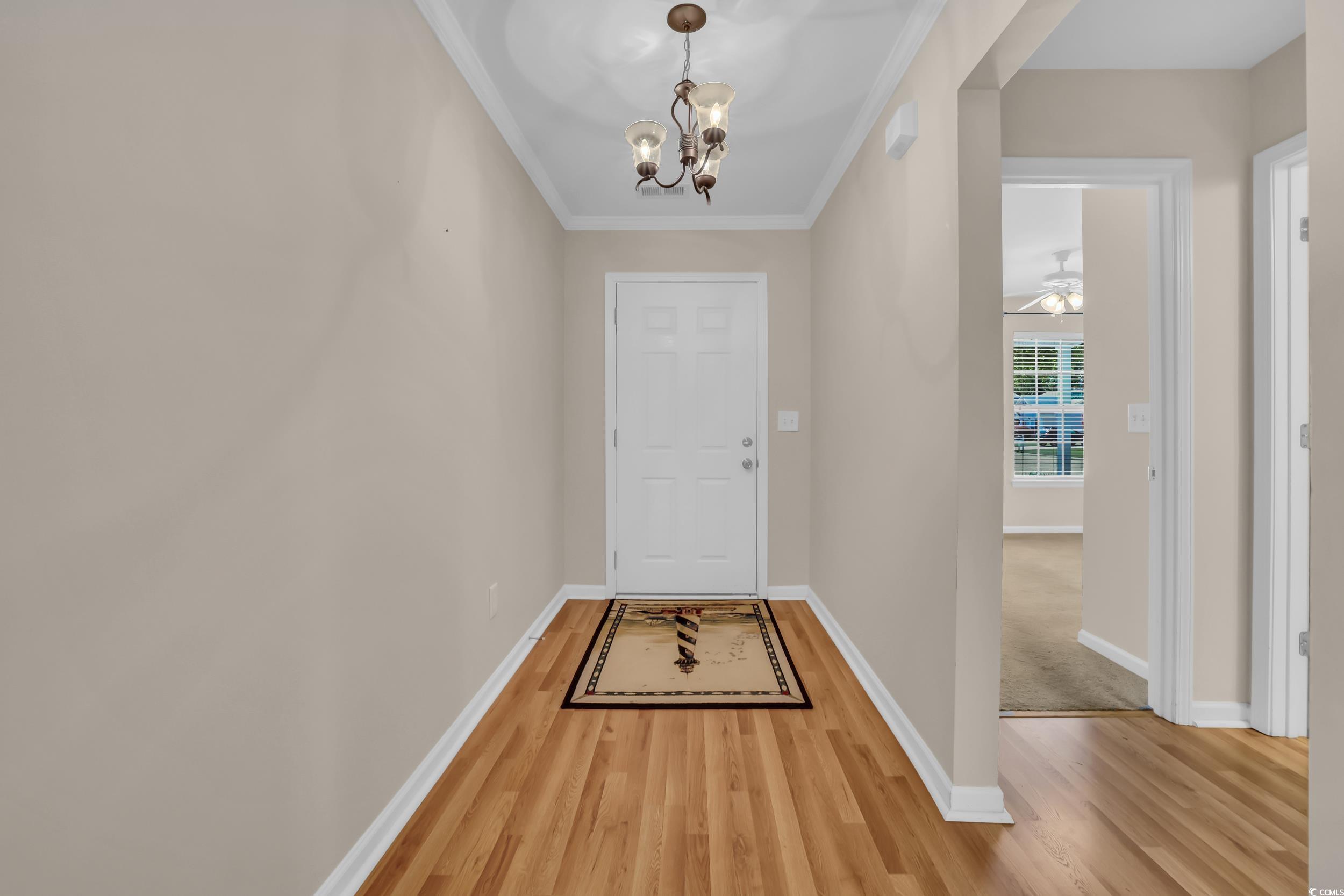 Doorway with a chandelier, ornamental molding, bas