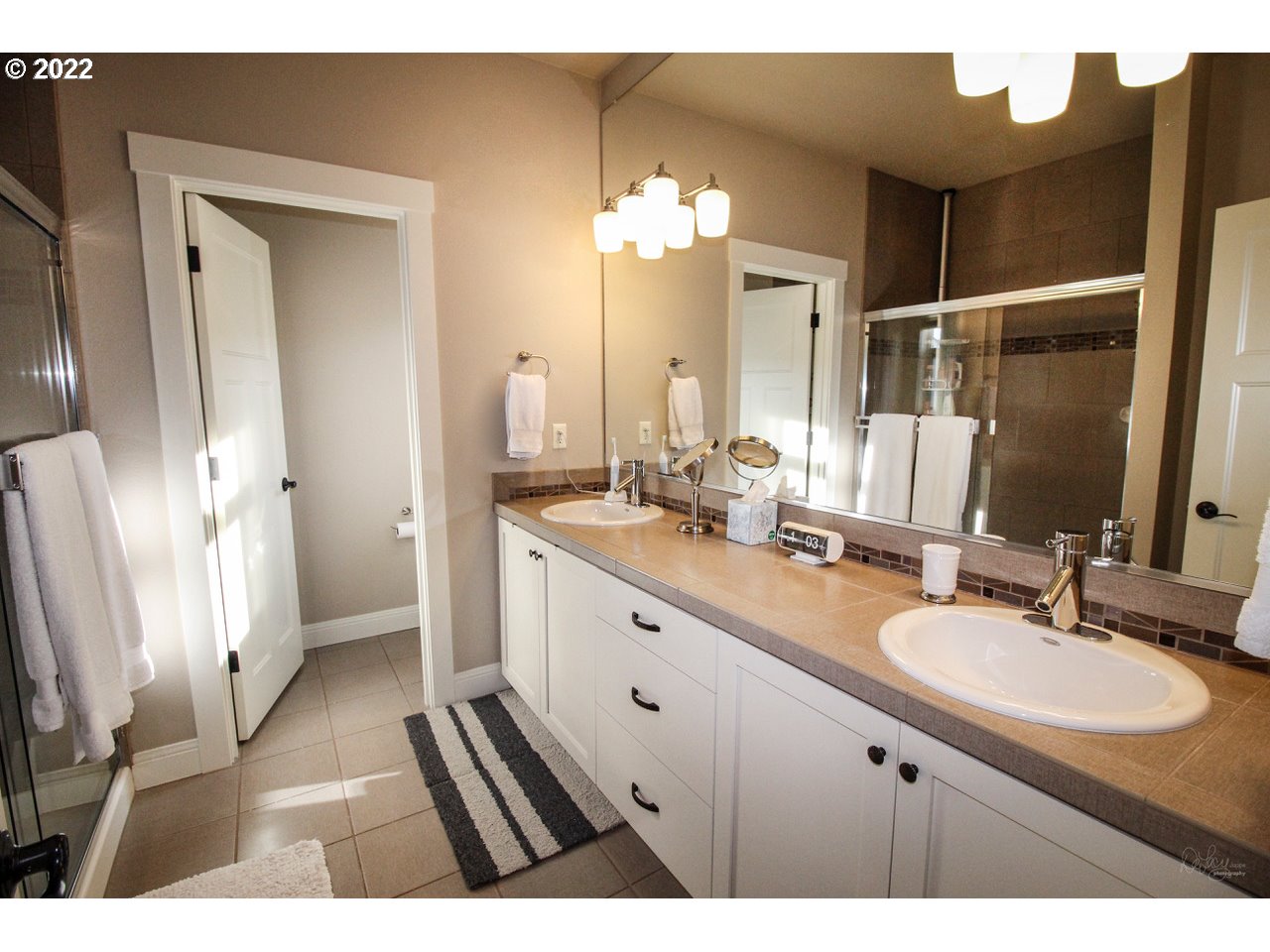 14174 Southwest Compass Drive Beaverton, OR 97005 - Photo 18 of 32 a bathroom with a double vanity sink a toilet and a mirror